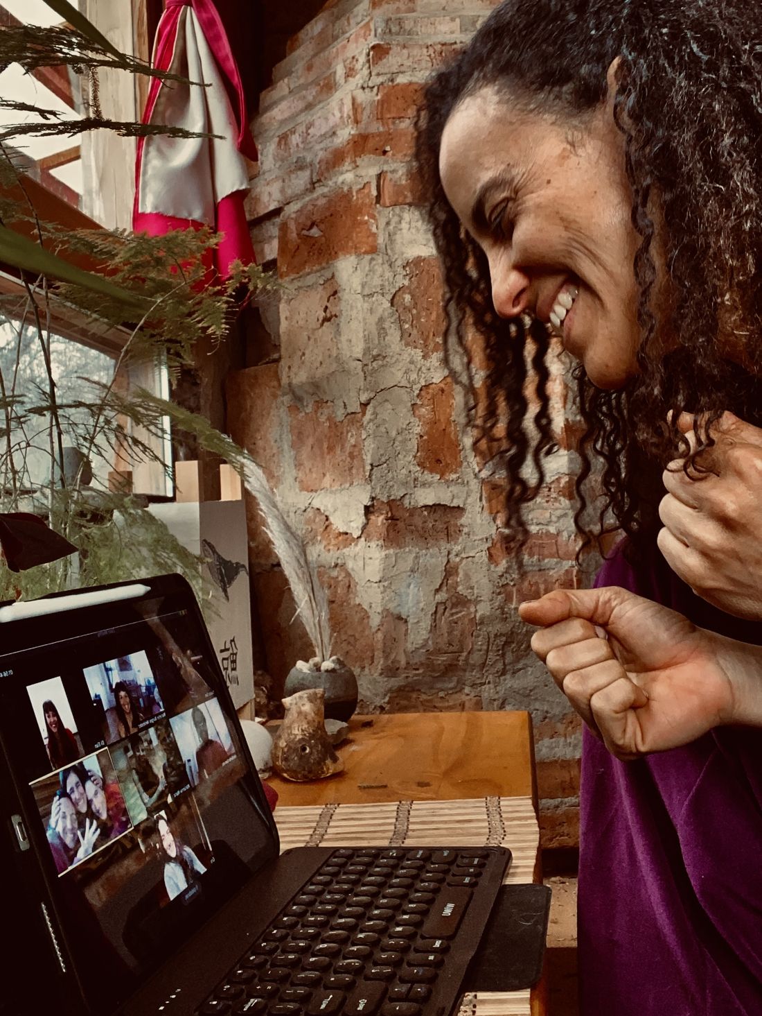 Carla sonriendo frente a una tablet durante un encuentro grupal por videollamada