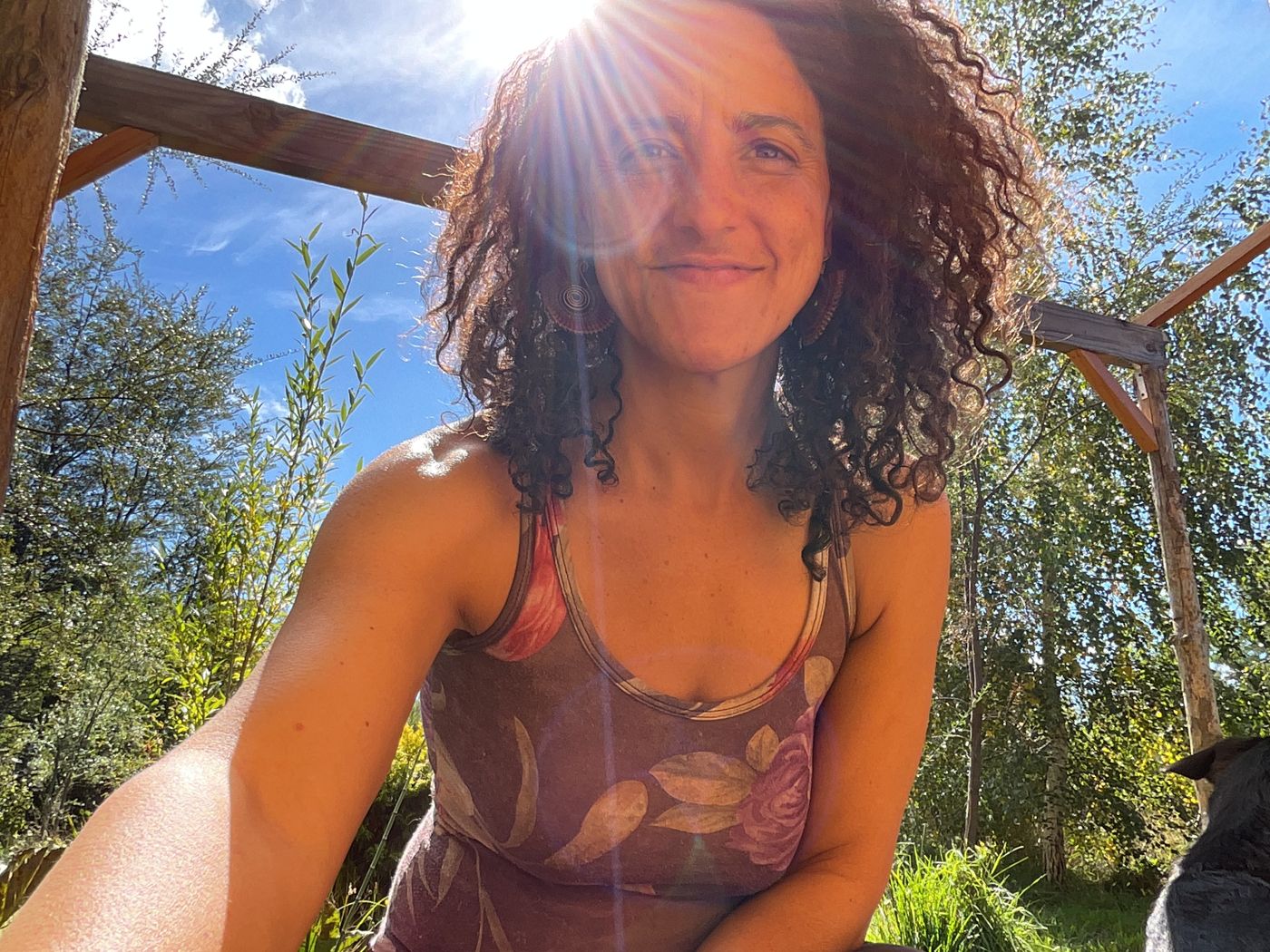 Carla Godreau sonriendo al aire libre, con el sol detrás